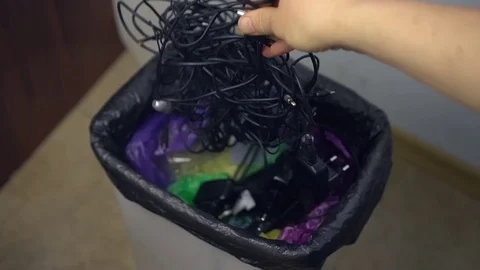 A man throws broken wires in a regular trash bin Stock Footage 122054798