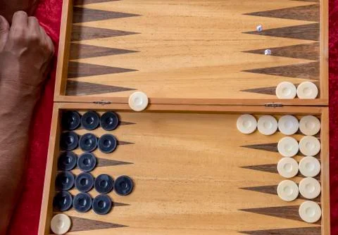 Man throws dice while playing backgammon. Stock Photos