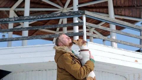 Man throws dog Jack Russell in the background of the lighthouse Vidéo 74912327