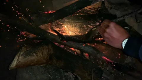 A man throws dry firewood into the fire. Stock-Footage 140085605