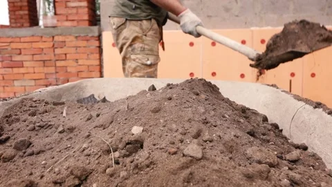 A man throws earth with a shovel into a construction cart Stock Footage 132778449