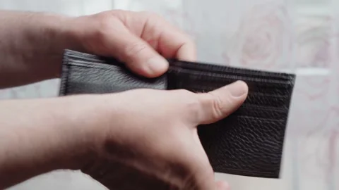 A man throws an empty leather wallet on the ground, close-up. Bankruptcy and Stock Footage 130858896