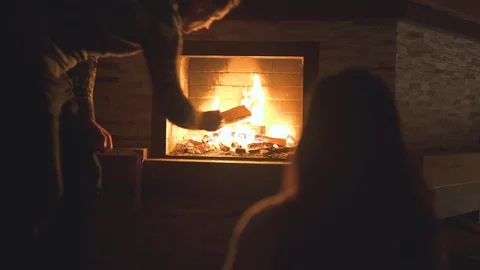 The man throws firewood into the fireplace Vídeos de archivo 123157247