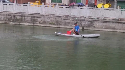 A man throws fish feed into a fish pond Video stock 134130209