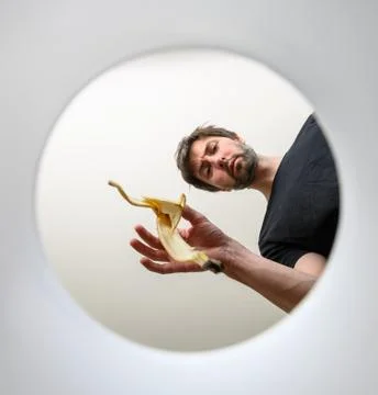 Man throws garbage into a bucket. inside view. throws out a banana skin Fotos Stock