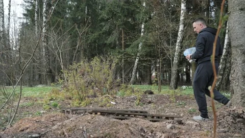 A man throws garbage in the forest 動画素材 153598434