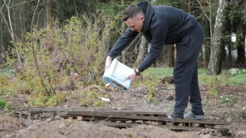 A man throws garbage in the forest Stock Footage 153688040