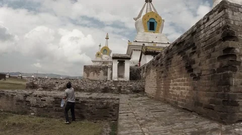 Man throws grain white dove on sacred Buddhist temple in old building against th Stock Footage 54648804
