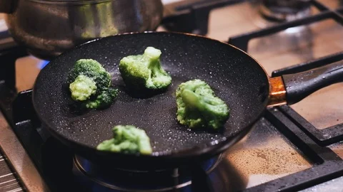 A man throws green beans in a frying pan with broccoli Stock Footage 124212340
