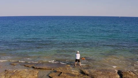 Man throws guitar in sea or ocean. Musician hippy grunge throws musical Stock Footage 126791028
