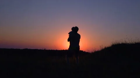 Man throws up his son at sunset Stock Footage 64709469