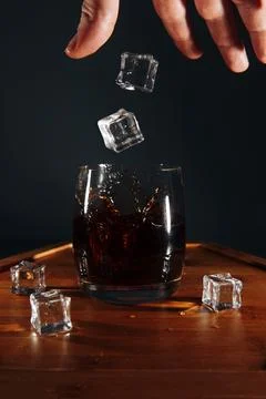 Man throws ice cubes into a cocktail Stock Photos
