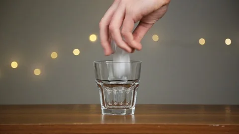 Man throws ice into a glass, then pours coconut water. Against the background of Stock Footage 106993596
