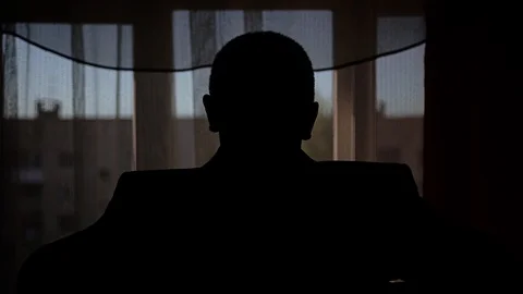 A man throws a jacket on his shoulders standing in front of the window Stock Footage 108957678
