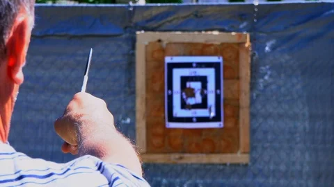 The man throws a knife into the target from a distance, the knife does not hit Stock Footage 90003336