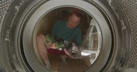 Man throws laundry washing machine. He throws objects in drum washing machine. 動画素材 201664894