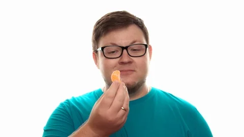 A man throws up a mandarin and catches it with his mouth Stock Footage 112770025