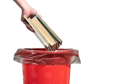 A man throws an old books into the trash bin Stock Photos