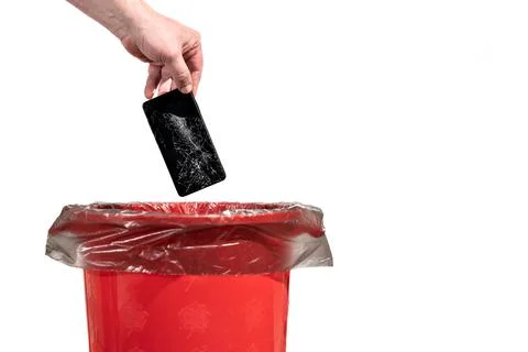 A man throws an old broken smartphone into the trash bin Stock Photos