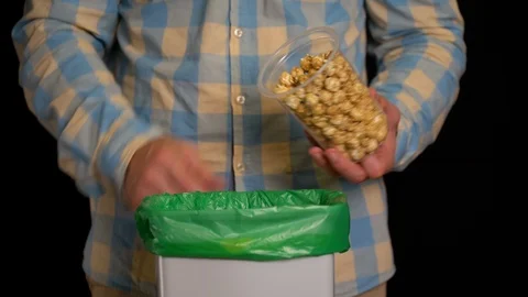 Man throws out a popcorn into garbage bin Stock Footage 116693538