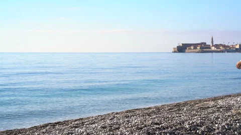 Man throws pebbles into the sea Stock Footage 151718423