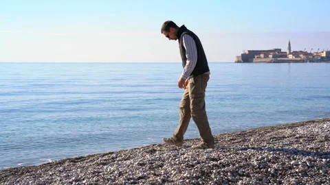 Man throws pebbles into the sea Stock Footage 151721870