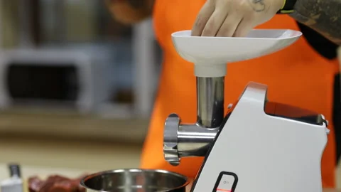 A man throws pieces of meat into a meat grinder. Stock Footage 167696637