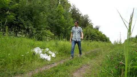A man throws a plastic bottle in the woods. Environmental pollution Stock Footage 133445117