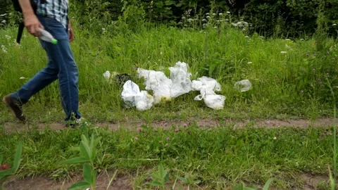A man throws a plastic bottle in the woods. Environmental pollution Stock Footage 133445151