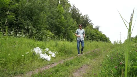 A man throws a plastic bottle in the woods. Environmental pollution Stock Footage 141792242