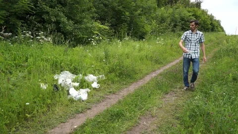 A man throws a plastic bottle in the woods. Environmental pollution Stock Footage 141792245