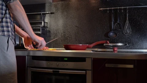 A man throws sausage from a cutting board into a frying pan Stock-Footage 86156866