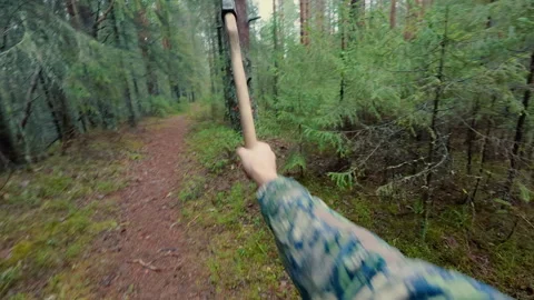 The man throws a sharp axe and sticks it into a tree the second time. Video stock 320944914