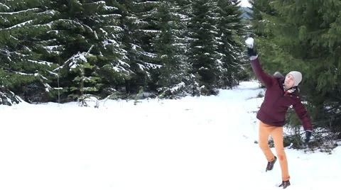 Man throws a snowball in the forest Stock Footage 56771585