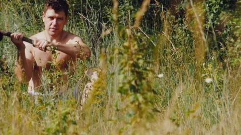 A man throws a stick German shepherd in the meadow and looks at the smartphone Stock Footage 111657735