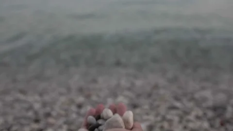 Man throws stones into the water. Hand close up Stock Footage 96595913