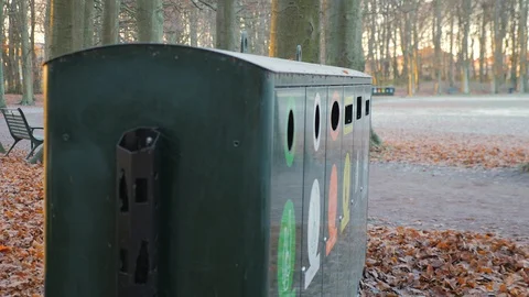 Man throws trash in a recycling station in a park Stock Footage 98988066