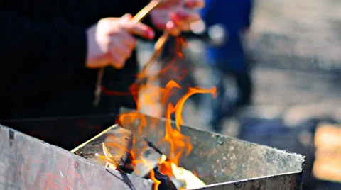 Man throws wood burning fire in an iron brazier Video stock 38245959