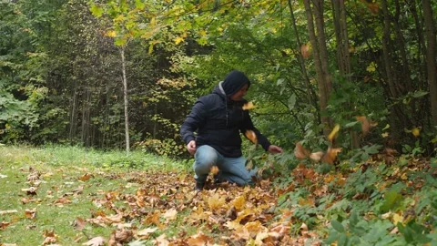 A man throws up yellow fallen leaves Stock Footage 171822759