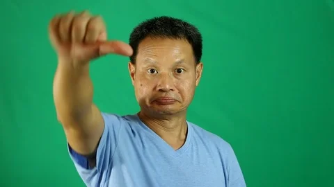Man thumb down with green background Stock Footage 96314326