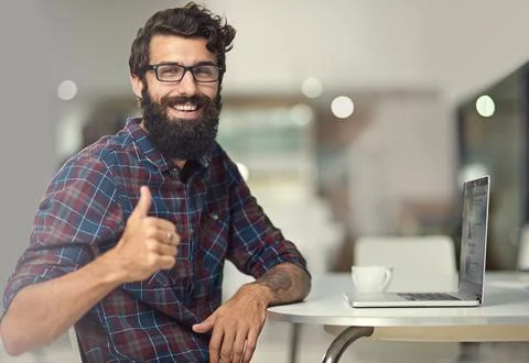 Man, thumbs up and laptop in creative workspace for online company, programming 库存照片