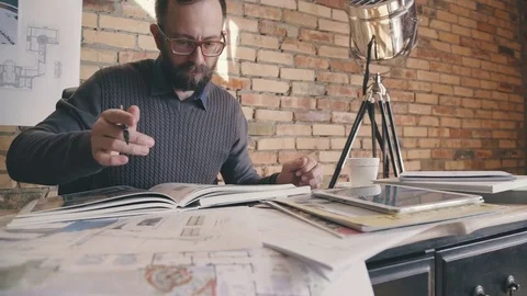 A man thumbs through a large book-catalog and makes important notes Stock Footage 73670544