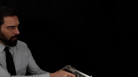 A man ticks walking in front of the camera with a gun in his hand. Stock Footage 143486518