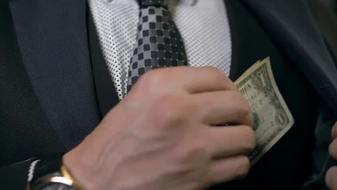 A man with a tie puts a banknote in the inner pocket of his jacket Stock Footage 89366762