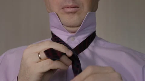 A man ties up a red tie. Video stock 85874378