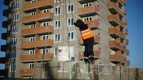 Man ties the ropes to the stone blocks and the crane lifts them Stock Footage 82141480
