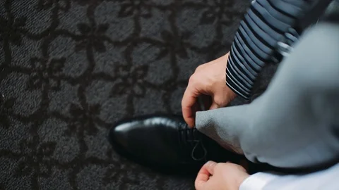 Man ties up shoelaces on black leather shoes, close-up. View from above. Stock Footage 123722458