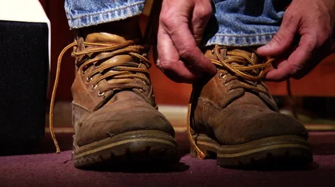 Man ties work boots Stock Footage