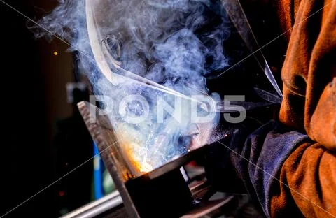 Man tig welding steel iron plates with brilliant bright white star burst bloo Stock Photos