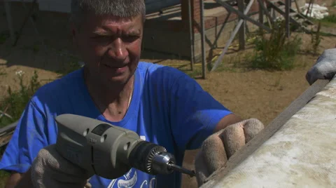 A man tightening the bolt with a drill Stock Footage 64775907